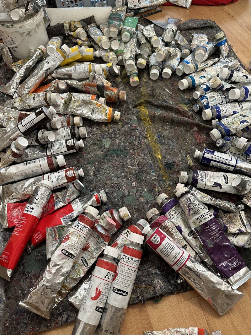 Ölfarben-Tuben kreisförmig auf der Malmatte im Atelier