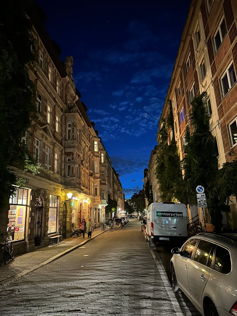 Die Kolonnadenstraße bei Nacht mit beleuchteten Schaufenstern und Bars